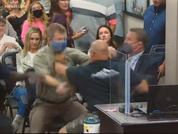 A man grabs a parent by the shirt at a heated Eastern Carver County, Minnesota school board meeting.