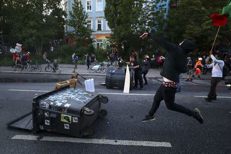 A protester throws an object towards riot police during clashes with anti-G20 protesters. REUTERS/Pawel Kopczynski