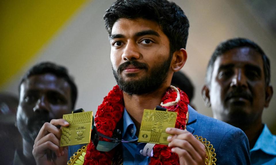 <span>Gukesh Dommaraju shows the Olympiad medals he won in Budapest after arriving in Chennai.</span><span>Photograph: R Satish Babu/AFP/Getty Images</span>