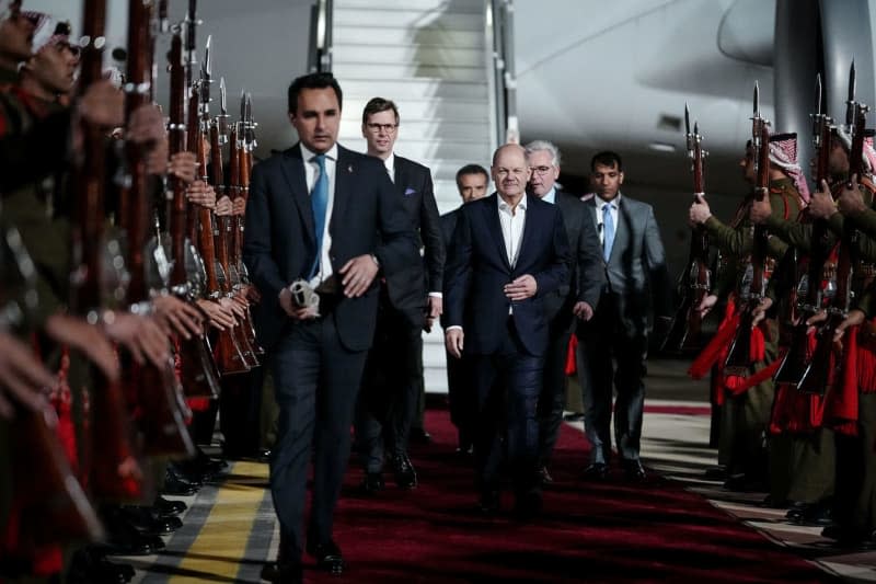 German Chancellor Olaf Scholz (C) arrives at the airport in Aqaba. Kay Nietfeld/dpa