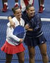 Flavia Pennetta of Italy (R) hugs compatriot Roberta Vinci as Vinci receives her runner-up trophy after Pennetta won their women's singles final match at the U.S. Open Championships tennis tournament in New York, September 12, 2015. REUTERS/Carlo Allegri