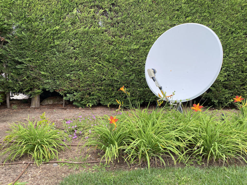 A satellite dish in someone's yard