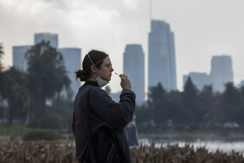 LOS ANGELES, CA - JANUARY 18: Lyndsey Marko of Echo Park takes a free PCR COVID-19 test at Echo Park on Tuesday, Jan. 18, 2022. The site was moved from Reservoir Street to provide a ``more convenient user experience'' amid a surge in COVID-19 cases related to the Omicron variant, Councilman Mitch O'Farrell said in an email to constituents Saturday. (Myung J. Chun / Los Angeles Times)