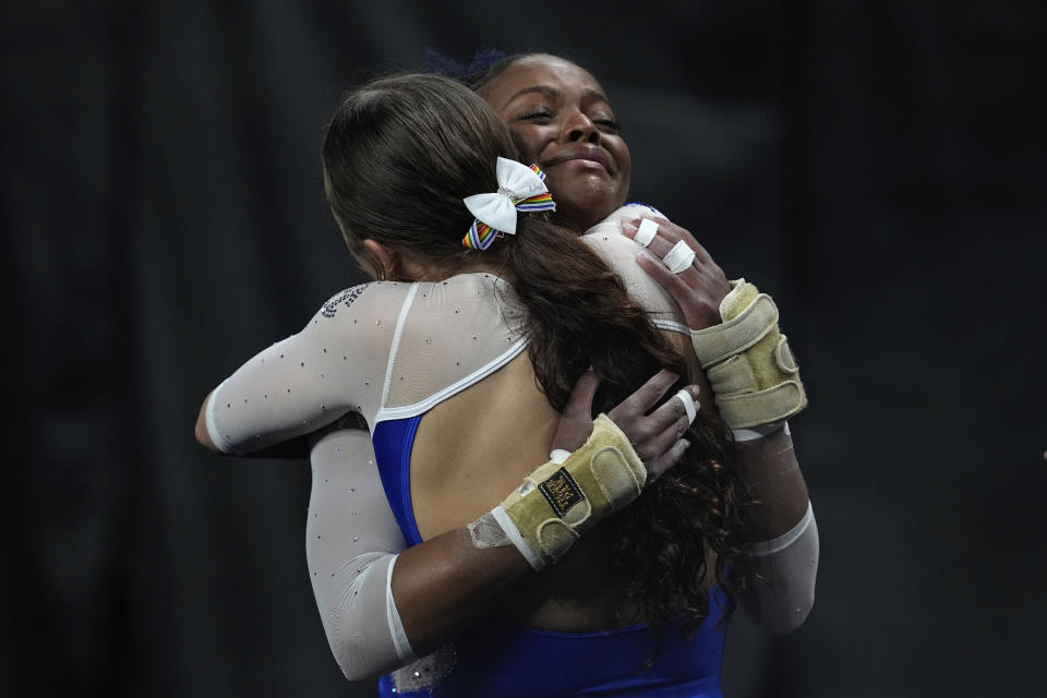 Florida's Trinity Thomas, right, hugs a teammate after competing in the vault exercise during the semifinals of the NCAA women's semifinals gymnastics championships, Thursday, April 13, 2023, in Fort Worth, Texas. (AP Photo/Tony Gutierrez)