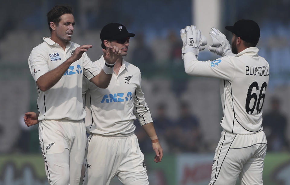 New Zealand's Tim Southee, left, celebrates the wicket of India's Mayank Agarwal with his teammates during the day four of their first test cricket match in Kanpur, India, Sunday, Nov. 28, 2021. (AP Photo/Altaf Qadri)