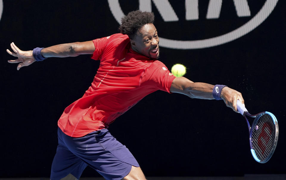 Gael Monfils of France makes a backhand return to Ernests Gulbis of Latvia during their third round singles match at the Australian Open tennis championship in Melbourne, Australia, Saturday, Jan. 25, 2020. (AP Photo/Lee Jin-man)