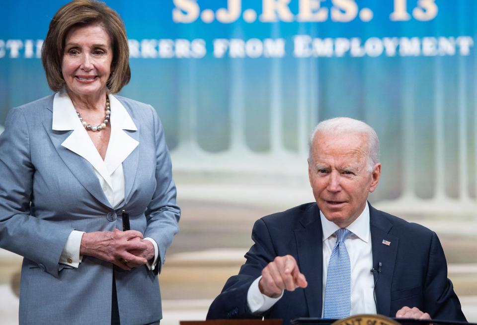 US President Joe Biden gestures alongside Speaker of the House Nancy Pelosi after signing S.J. Res. 13, a bill dealing with Employment Discrimination, during a ceremony in the Eisenhower Executive Office Building in Washington, DC on June 30, 2021. (Photo by SAUL LOEB / AFP)