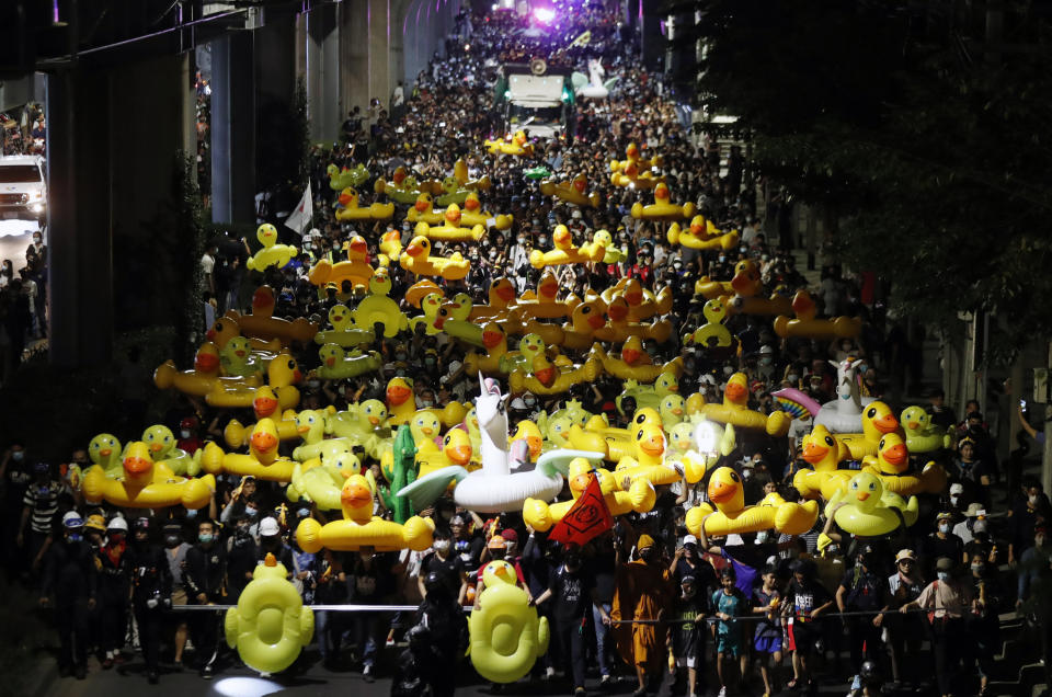 Protesters carry inflatable yellow ducks, which have become good-humored symbols of resistance during anti-government rallies, while marching towards the base of the 11th Infantry Regiment,a palace security unit under direct command of the Thai king, Sunday,Nov. 29, 2020 in Bangkok, Thailand. Pro-democracy demonstrators are continuing their protests calling for the government to step down and reforms to the constitution and the monarchy, despite legal charges being filed against them and the possibility of violence from their opponents or a military crackdown. (AP Photo/Sakchai Lalit)