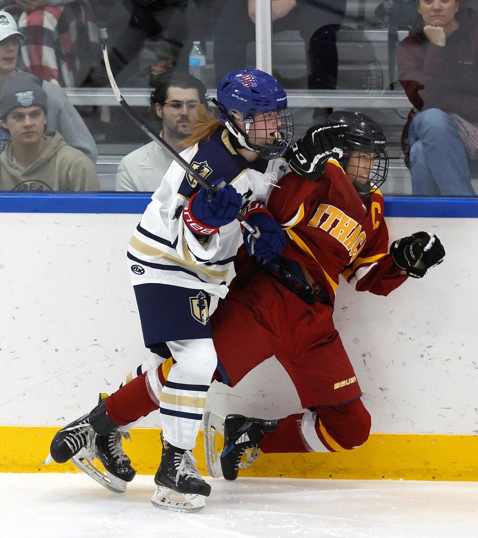 Webster’s Eve Pagano checks Ithaca’s Kaylee Holly along the boards.