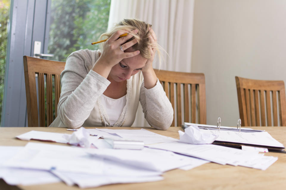 Woman looks worried as she looks over investment paperwork.