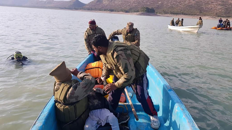 In this photo released by Inter Services Public Relations, army soldier head back after recovered a child body during search operation in Tanda Dam, in Kohat, a district of Pakistan's Khyber Pakhtunkhwa province, Tuesday, Jan. 31, 2023. The death toll from a boating accident in a lake in northwest Pakistan over the weekend reached 51, the military said Tuesday. The vessel was carrying children and teachers from a seminary on a picnic. (Inter Services Public Relations via AP)