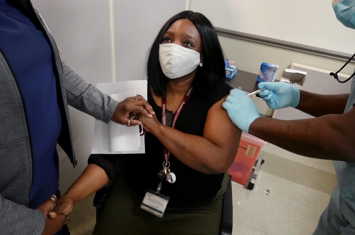 <span class="caption">Latrice Davis, a nurse at Roseland Community Hospital in Chicago, receives the COVID-19 vaccine on Dec. 18, 2020. </span> <span class="attribution"><a class="link " href="https://www.gettyimages.com/detail/news-photo/latrice-davis-a-nurse-at-roseland-community-hospital-news-photo/1292016675?adppopup=true" rel="nofollow noopener" target="_blank" data-ylk="slk:Scott Olson via Getty Images;elm:context_link;itc:0;sec:content-canvas">Scott Olson via Getty Images</a></span>