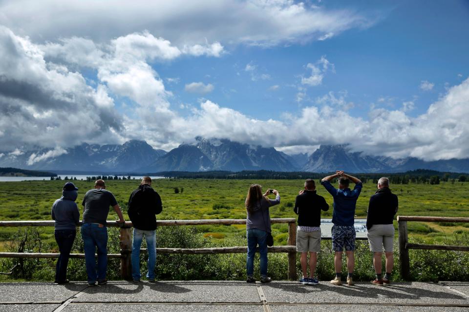 Tourists look out at the mountains from the Jackson Lake Lodge in Grand Teton National Park near Jackson, Wyo. in this file photo from Aug. 21, 2014.