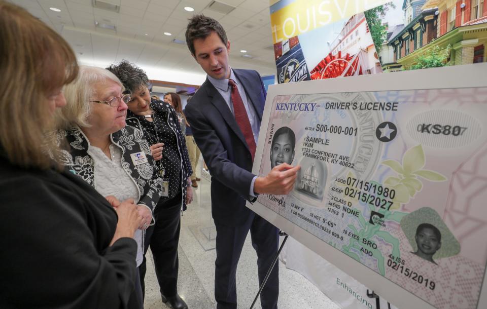 Kentucky Vehicle Regulation Commissioner Matt Henderson, right, speaks with county clerks during a 2018 press conference at Louisville International Airport.  The clerks were on hand to see and hear about Kentucky's new driver's license that will be REAL ID compliant and will begin to be available in Kentucky's 120 counties in early 2019.