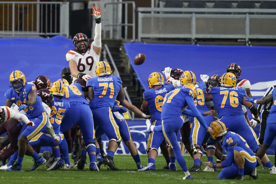 Pittsburgh place kicker Alex Kessman (97), center, hits a field goal as Virginia Tech's Luke Tenuta (69) leaps in an effort to block it during the first half of an NCAA college football game, Saturday, Nov. 21, 2020, in Pittsburgh. (AP Photo/Keith Srakocic)