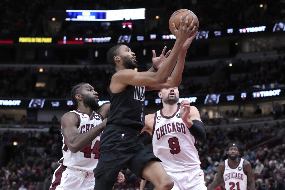 Brooklyn Nets' Mikal Bridges drives to the basket as Chicago Bulls' Patrick Williams (44) and Nikola Vucevic defend during the first half of an NBA basketball game Friday, Feb. 24, 2023, in Chicago. (AP Photo/Charles Rex Arbogast)