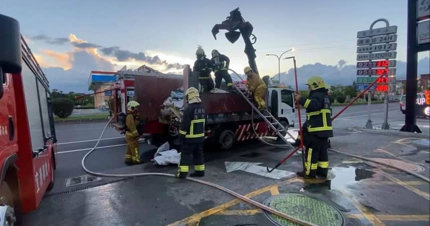 1輛抓斗車所載運的廢棄物忽然起火，駕駛只能將車輛停在加油站旁，用加油站洗車的水源與滅火器控制火勢。（圖／民眾提供）