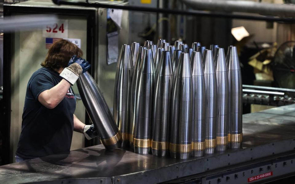 An employee handles 155 mm caliber shells after the manufacturing process at the Scranton Army Ammunition Plant