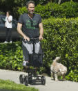 <p>An injured Eric McCormack uses a scooter to take his dog out on Monday in L.A. </p>