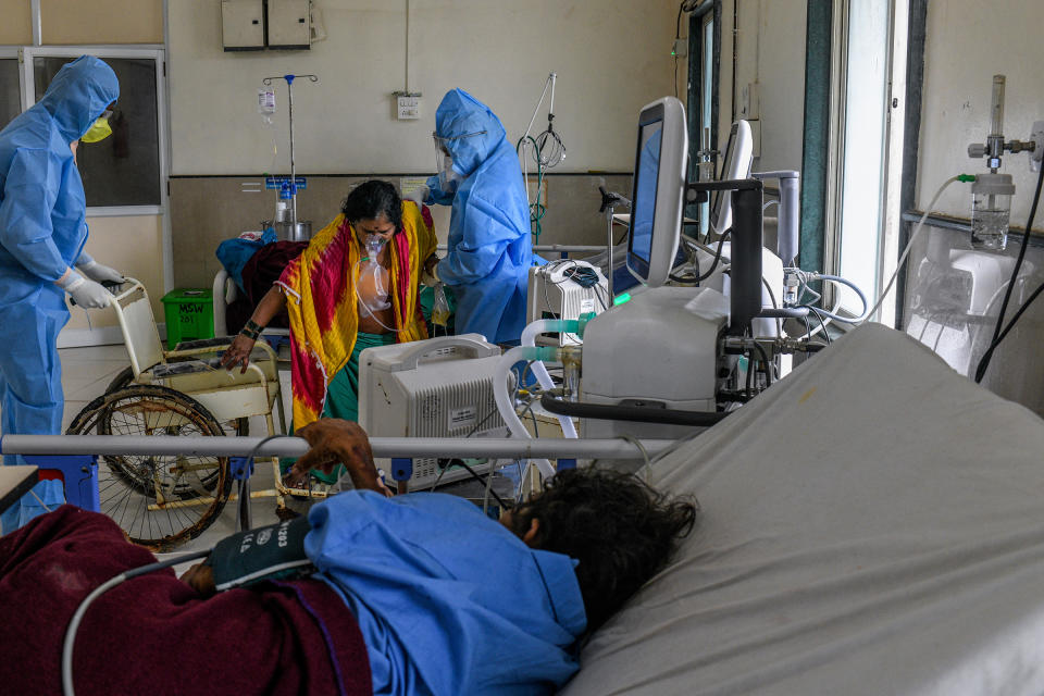 After her condition improved, a COVID-19 patient is helped into a wheelchair so she can be transferred from the intensive-care unit to an observation ward.<span class="copyright">Atul Loke for TIME</span>