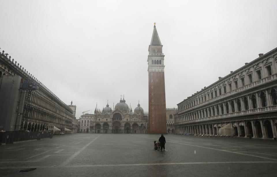 A greengrocer carries his cart as the water begins to flood St. Mark's Square on the occasion of a high tide, in Venice, Italy, Tuesday, Nov. 12, 2019. The high tide reached a peak of 127cm (4.1ft) at 10:35am while an even higher level of 140cm(4.6ft) was predicted for later Tuesday evening. (AP Photo/Luca Bruno)