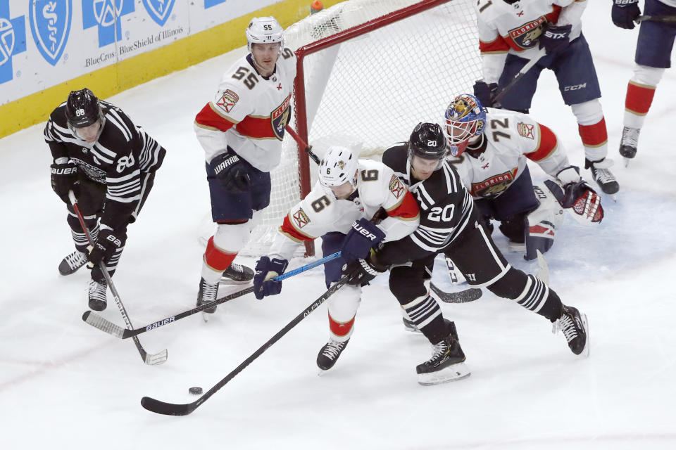 Florida Panthers' Anton Stralman (6) and Chicago Blackhawks' Brandon Saad (20) battle for a loose puck during the first period of an NHL hockey game Tuesday, Jan. 21, 2020, in Chicago. (AP Photo/Charles Rex Arbogast)