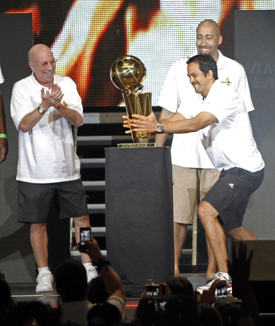 FILE - Miami Heat coach Erik Spoelstra grabs the NBA championship trophy as assistant coaches Ron Rothstein, left, and David Frizdale watch in Miami, Monday, June 25, 2012. The biggest names on the U.S. World Cup roster might be those who’ll be wearing polo shirts instead of jerseys on game days. Team USA assistant coach Erik Spoelstra has three rings, two as a head coach. (AP Photo/Alan Diaz, File)