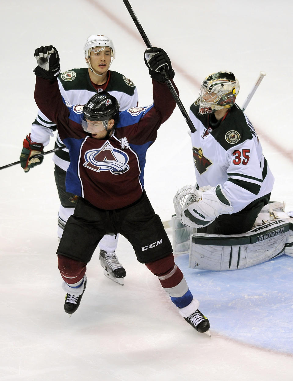 Colorado Avalanche center Paul Stastny, front left, celebrates a game-winning goal by Nathan MacKinnon as Minnesota Wild defenseman Jared Spurgeon, rear, and goalie Darcy Kuemper, right, look on in overtime in Game 5 of an NHL hockey first-round playoff series on Saturday, April 26, 2014, in Denver. The Avalanche won 4-3. (AP Photo/Chris Schneider)