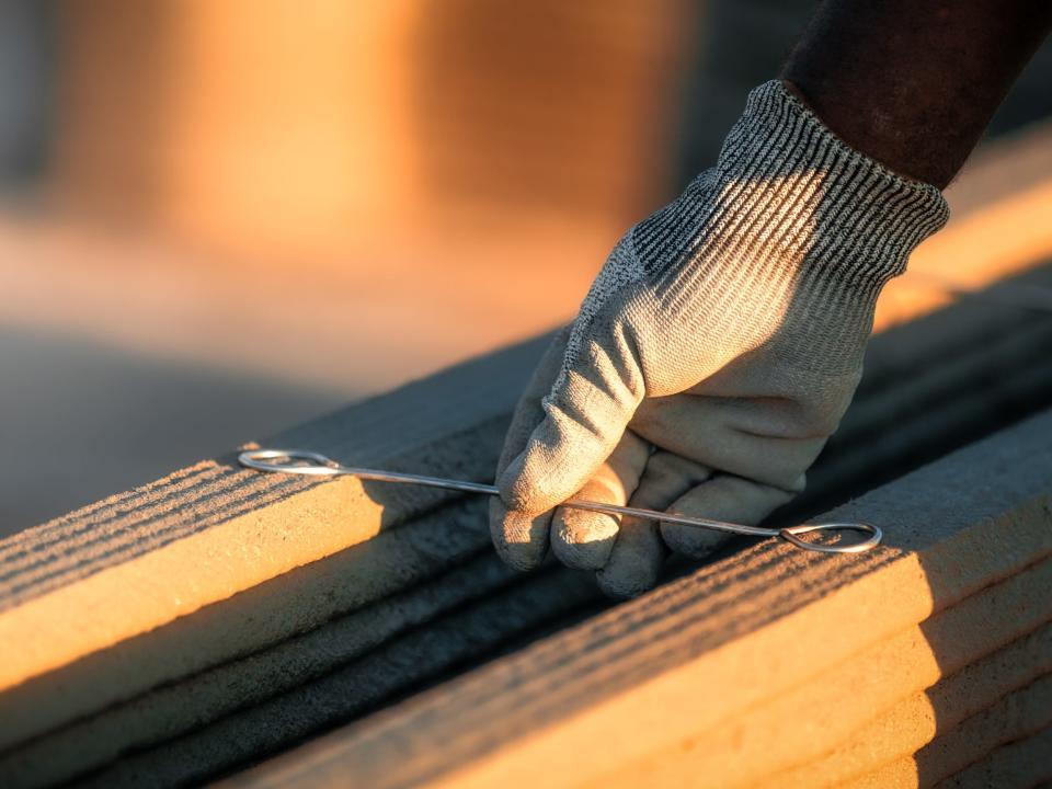 A hand holding a tool next to 3d printed walls