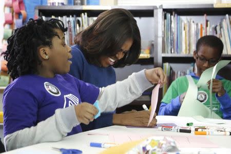 U.S. first lady Michelle Obama laughs as she works on a literacy project with children during a day of service at the Boys & Girls Club of Greater Washington, in celebration of the Martin Luther King, Jr. holiday in Washington January 19, 2015. REUTERS/Jonathan Ernst