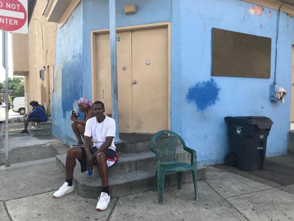 Kevin Johnson, foreground, sits in the shade of building in Wilmington's West Center City. Johnson said increased days of extreme heat leads to more tension in the neighborhood.