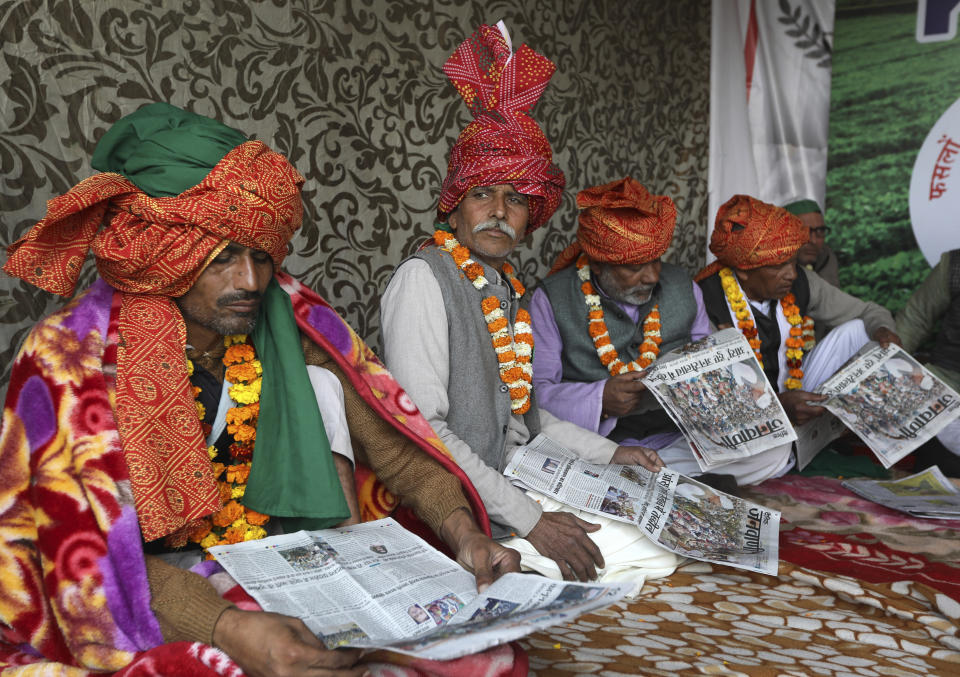 Farmers read local newspapers as they participate in a day-long hunger strike to protest against farm laws at the Delhi-Uttar Pradesh border, on the outskirts of New Delhi, India, Saturday, Jan. 30, 2021. Indian farmers and their leaders spearheading more than two months of protests against new agriculture laws began a daylong hunger strike Saturday, directing their fury toward Prime Minister Narendra Modi and his government. Farmer leaders said the hunger strike, which coincides with the death anniversary of Indian independence leader Mahatma Gandhi, would reaffirm the peaceful nature of the protests. (AP Photo/Manish Swarup)
