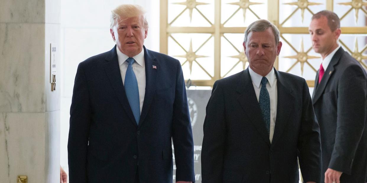 President Donald Trump, left, walks with Supreme Court Chief Justice John Roberts as he arrives to view the casket of Justice John Paul Stevens at the Supreme Court, Monday, July 22, 2019.