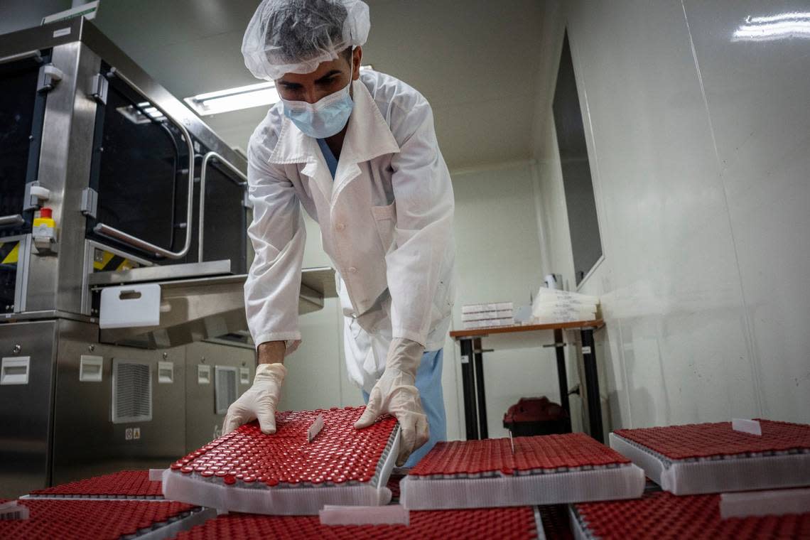 A worker at the National Center for Bio-preparations, Biocen, moves vials of the Cuban-made VA-Mengoc-BC vaccine for meningococcal disease as they are prepared for packaging in Bejucal, Cuba, Friday, July 15, 2022.