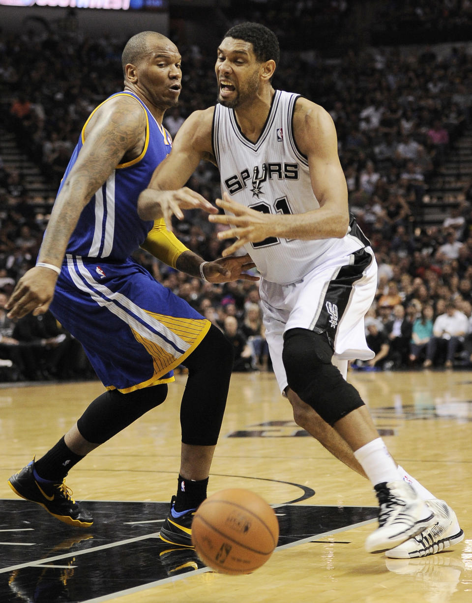 San Antonio Spurs forward Tim Duncan, right, loses the ball as he drives around Golden State Warriors forward Marreese Speights during the first half of an NBA basketball game on Wednesday, April 2, 2014, in San Antonio. (AP Photo/Darren Abate)