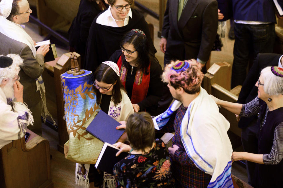 In this Saturday, Feb. 1, 2020, photo, Rabbi Jacqueline Mates-Muchin follows Hanna Raskin as she carries a Torah scroll during her bat mitzvah at Temple Sinai in Oakland, Calif. Mates-Muchin says there’s extra worry as she feels obliged to be constantly mindful of her congregation’s safety. (AP Photo/Noah Berger)