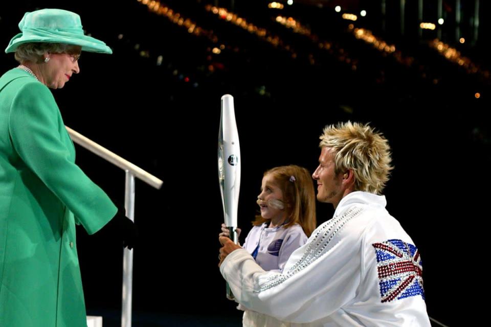 David Beckham and Kirsty Howard handing the Queens Jubille Baton to Queen Elizabeth II after it’s  final leg around the city of Manchester stadium, at the opening ceremony of the Commonwealth Games. (Phil Noble/PA)