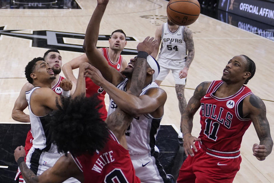 San Antonio Spurs guard Malaki Branham, center, scramble for a rebound between Chicago Bulls guard Coby White (0) and forward DeMar DeRozan (11) during the second half of an NBA basketball game in San Antonio, Saturday, Jan. 13, 2024. (AP Photo/Eric Gay)