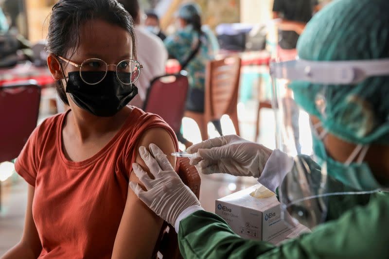 FILE PHOTO: A woman receives a dose of AstraZeneca COVID-19 vaccine during a mass vaccination programme for Green Zone Tourism in Sanur, Bali, Indonesia,