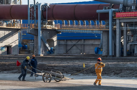 Workers walk at the cement plant built jointly by Chinese Gezhouba Group and Kazakh firm Corporation DANAKE on the outskirts of the village of Shieli, southern Kazakhstan December 11, 2018. REUTERS/Mariya Gordeyeva