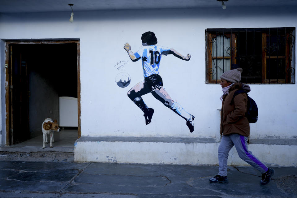 Una mujer camina por delante de un mural de la leyenda del fútbol argentino Diego Maradona, en San Antonio de los Cobres, Salta, Argentina, el martes 3 de octubre de 2023. En San Antonio de los Cobres, el candidato presidencial Javier Milei obtuvo el 60% de los votos en las primarias. (AP Foto/Natacha Pisarenko)