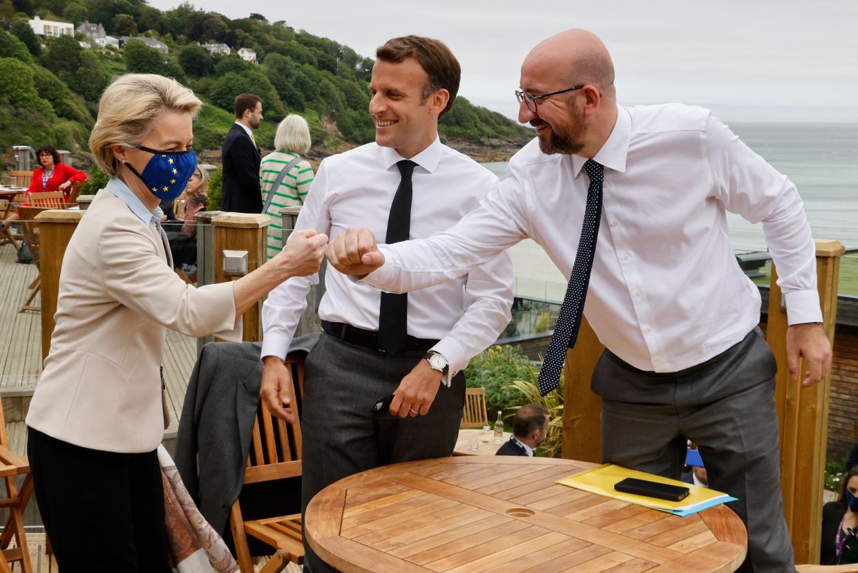 TOPSHOT - (L-R) President of the European Commission Ursula von der Leyen, France's President Emmanuel Macron, and President of the European Council Charles Michel bump fists during an EU coordination meeting in advance of the start of the G7 summit in Carbis bay, Cornwall on June 11, 2021. (Photo by Ludovic MARIN / AFP) (Photo by LUDOVIC MARIN/AFP via Getty Images)