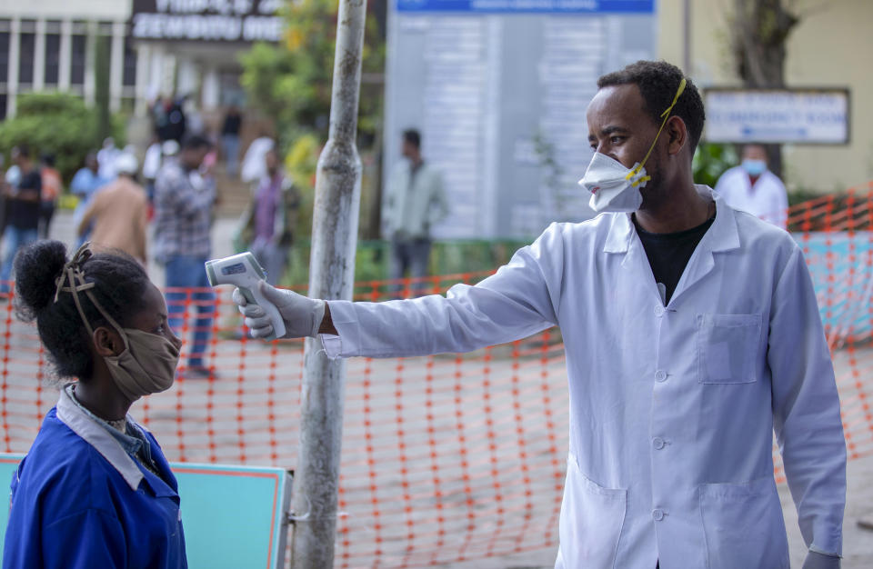 Ethiopians have their temperature checked for symptoms of the new coronavirus, at the Zewditu Memorial Hospital in the capital Addis Ababa, Ethiopia Wednesday, March 18, 2020. For most people, the new coronavirus causes only mild or moderate symptoms such as fever and cough and the vast majority recover in 2-6 weeks but for some, especially older adults and people with existing health issues, the virus that causes COVID-19 can result in more severe illness, including pneumonia. (AP Photo/Mulugeta Ayene)