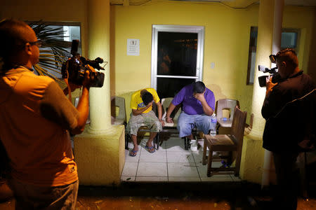 Jose Faustino Diaz Lopez (R), 25, and Wilmer Francisco Pastrana Carcamo, (L), 18, sit in a police station in San Pedro Sula, Honduras, October 2, 2018. REUTERS/Goran Tomasevic