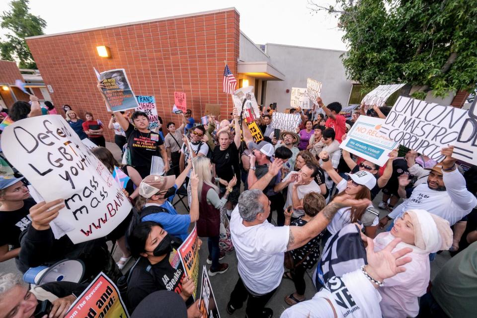 Parents face off outside an Orange Unified School District board meeting in Orange.