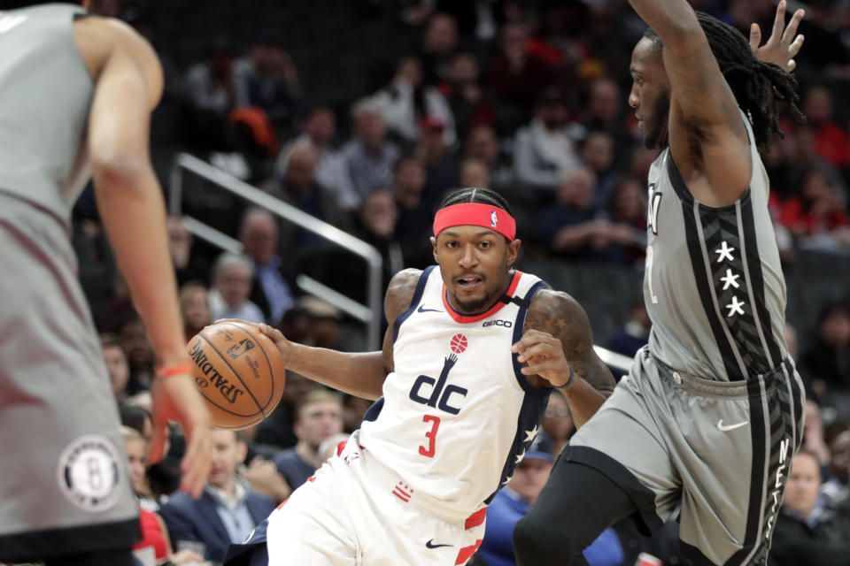 Washington Wizards' Bradley Beal (3) moves the ball past Brooklyn Nets' Taurean Prince, right, during the first half of an NBA basketball game Wednesday, Feb. 26, 2020, in Washington. (AP Photo/Luis M. Alvarez)