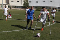 Coach Simon Baker, an International Committee of the Red Cross (ICRC) consultant and founder of the Irish Amputee Football Association, trains amputee players of the first Palestinian national team for amputee football, at Palestine Stadium in Gaza City, Sunday, Dec. 5, 2021. The ICRC, working with Palestinian Amputee Football Association, sponsored the long process of forming the national team. The players hope to compete regionally, their sights set on the World Cup for amputees in Turkey next October. (AP Photo/Adel Hana)