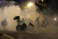 Tear gas fills the air during protests, Friday, Sept. 18, 2020, in Portland, Ore. The protests, which began over the killing of George Floyd, often result frequent clashes between protesters and law enforcement. (AP Photo/Paula Bronstein)