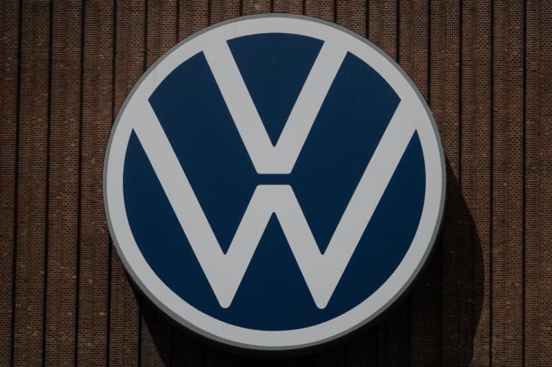 The Volkswagen logo hangs on the outside facade of the Volkswagen plant in Wolfsburg. Melissa Erichsen/dpa