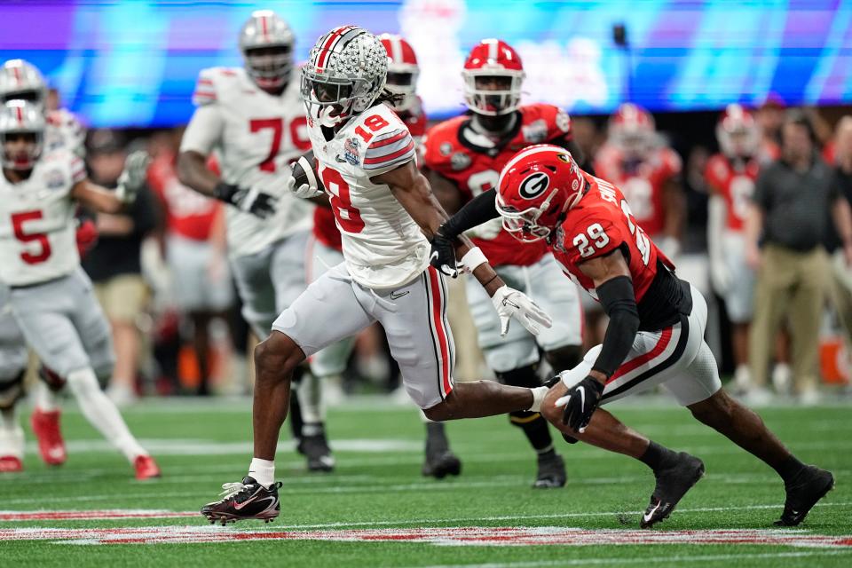 Dec 31, 2022; Atlanta, Georgia, USA; Ohio State Buckeyes wide receiver Marvin Harrison Jr. (18) runs past Georgia Bulldogs defensive back Christopher Smith (29) after making a catch during the first half of the Peach Bowl in the College Football Playoff semifinal at Mercedes-Benz Stadium. Mandatory Credit: Adam Cairns-The Columbus Dispatch